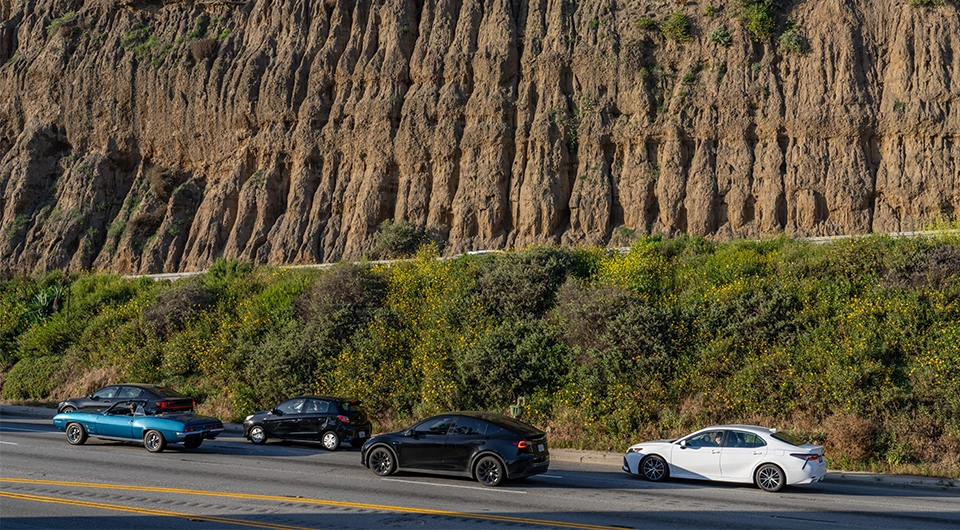 cars on the road in front of mountainside