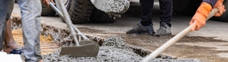 People placing concrete with tools